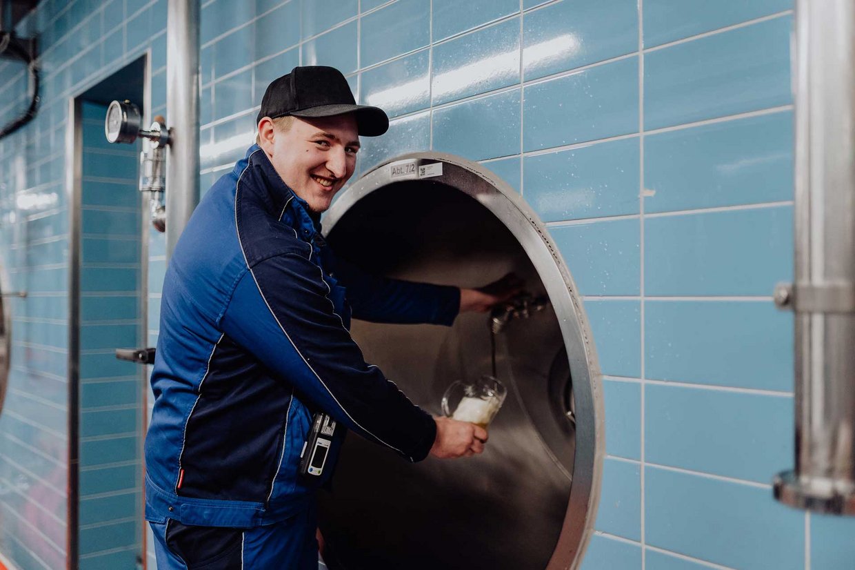 Ein Mitarbeiter der Brauerei nimmt eine Probe vom Zwickelbier